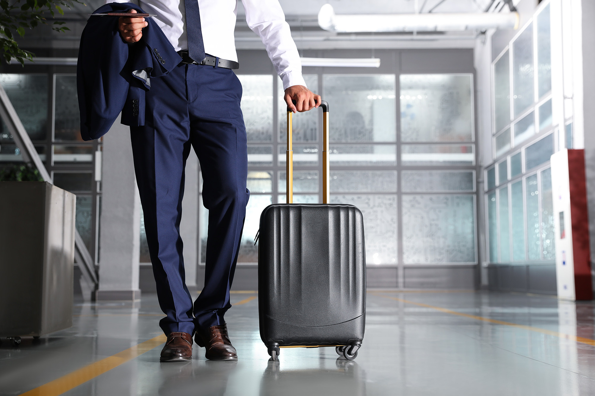 Businessman with black travel suitcase in airport. Space for text